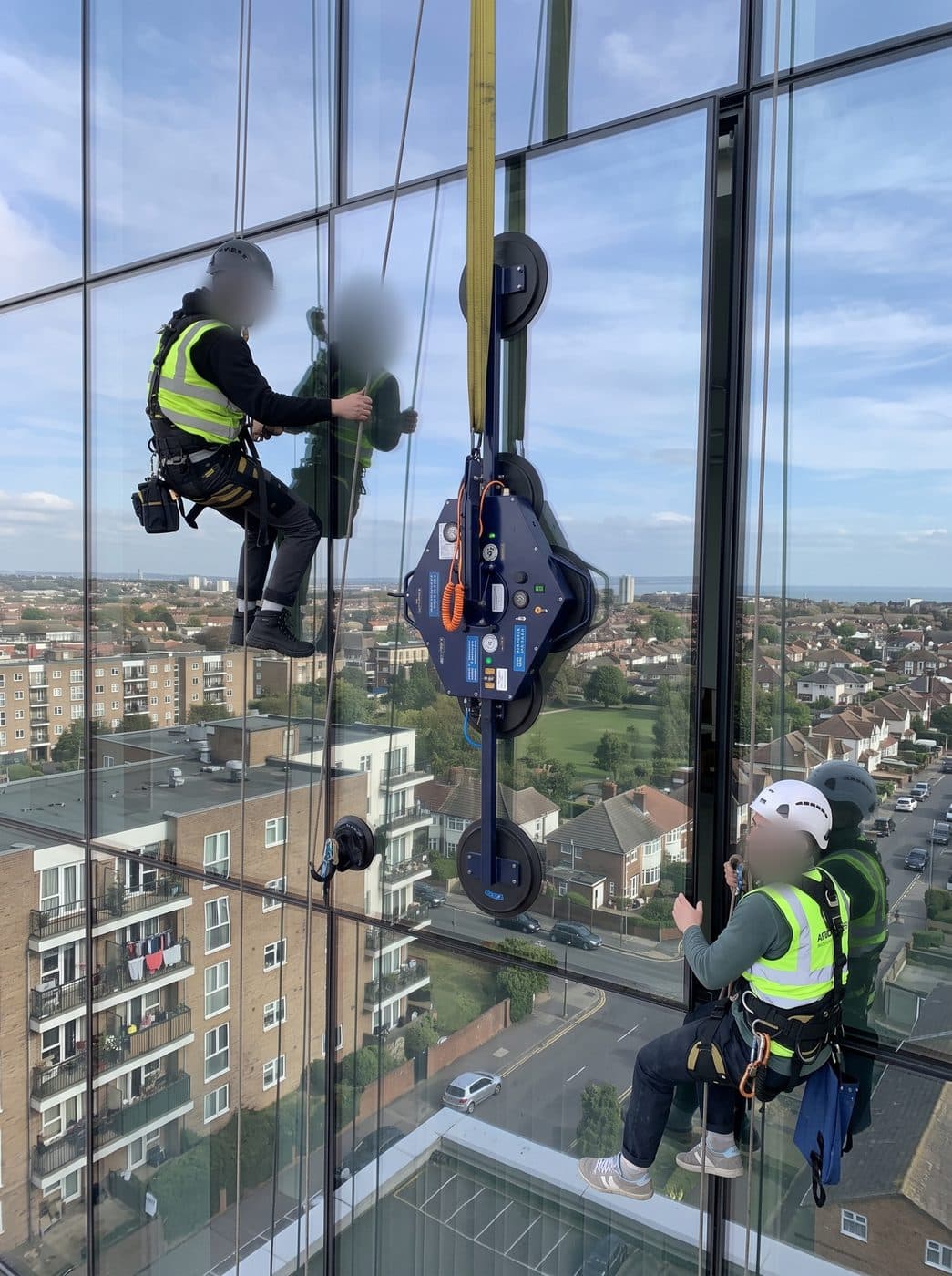 Illustration of two rope access technicians positioning a glazing unit with a vacuum lifter