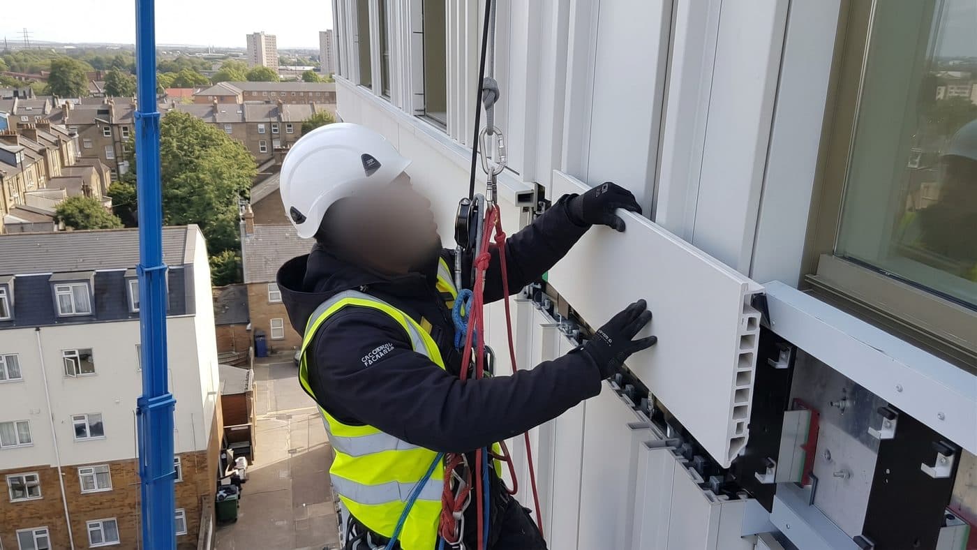 Illustration of a technician locating a facade panel into its rail system