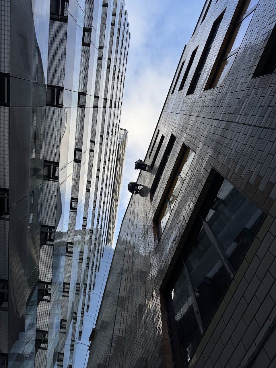 Two Innova rope access technicians suspended in the alley behind the rear elevation of The Baltic Exchange