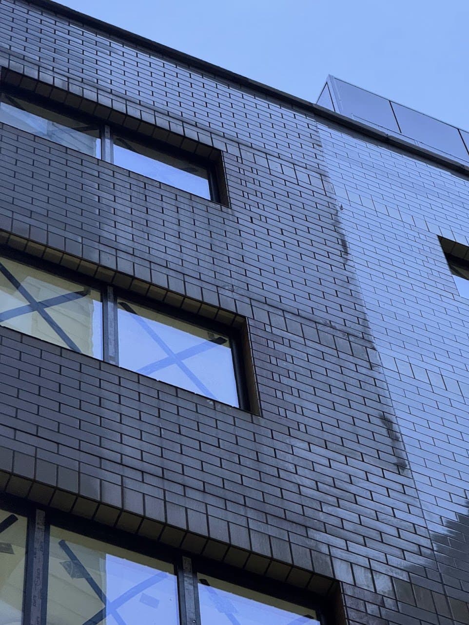 Mid-clean contrast on the dark glazed brickwork, treated and untreated side by side