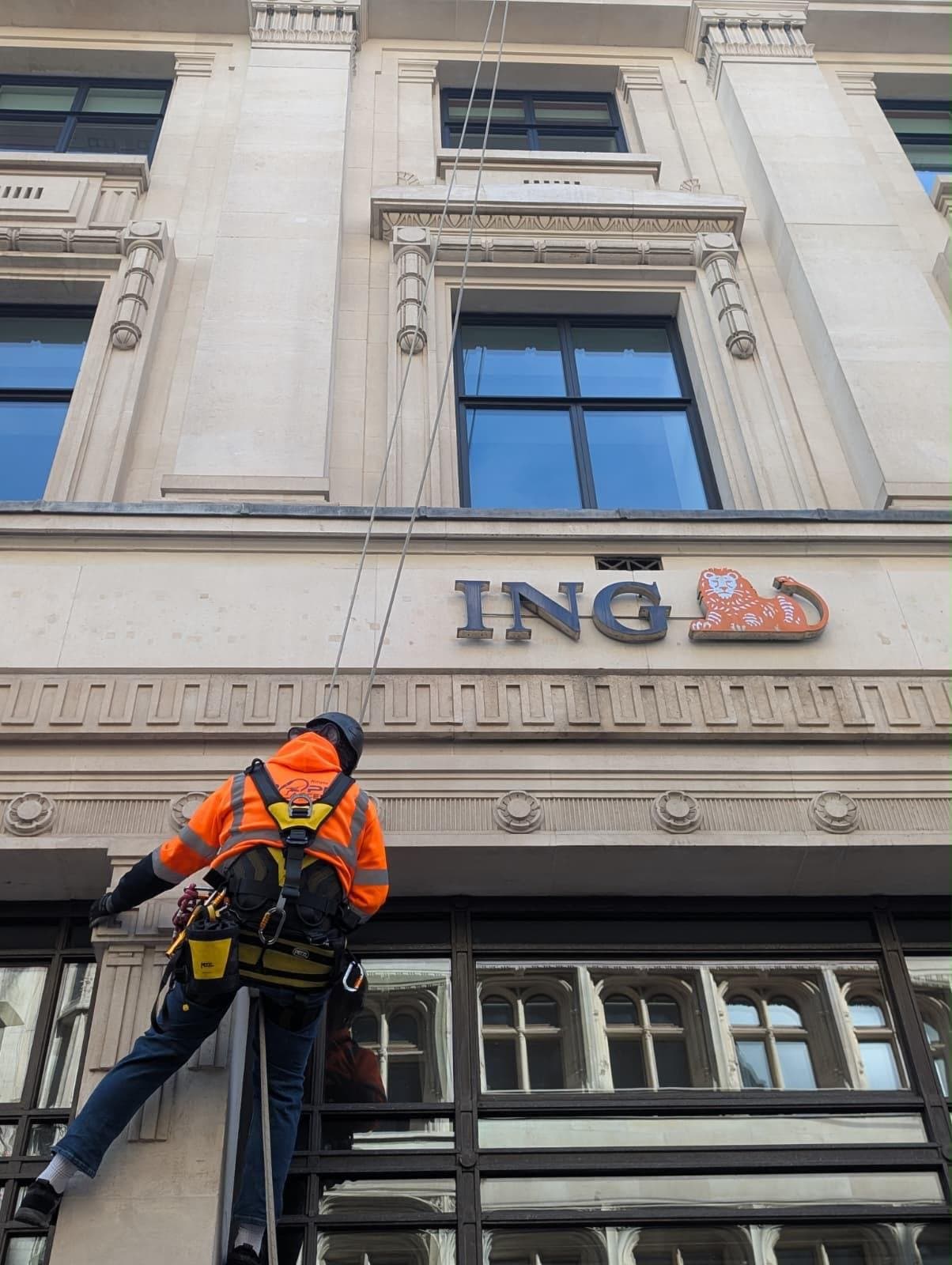 Rope access technician cleaning the stone elevation of the ING office in the City of London