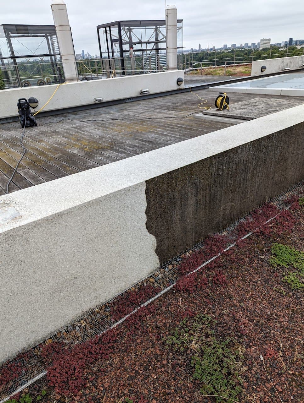 Pressure washing the parapet above the London skyline