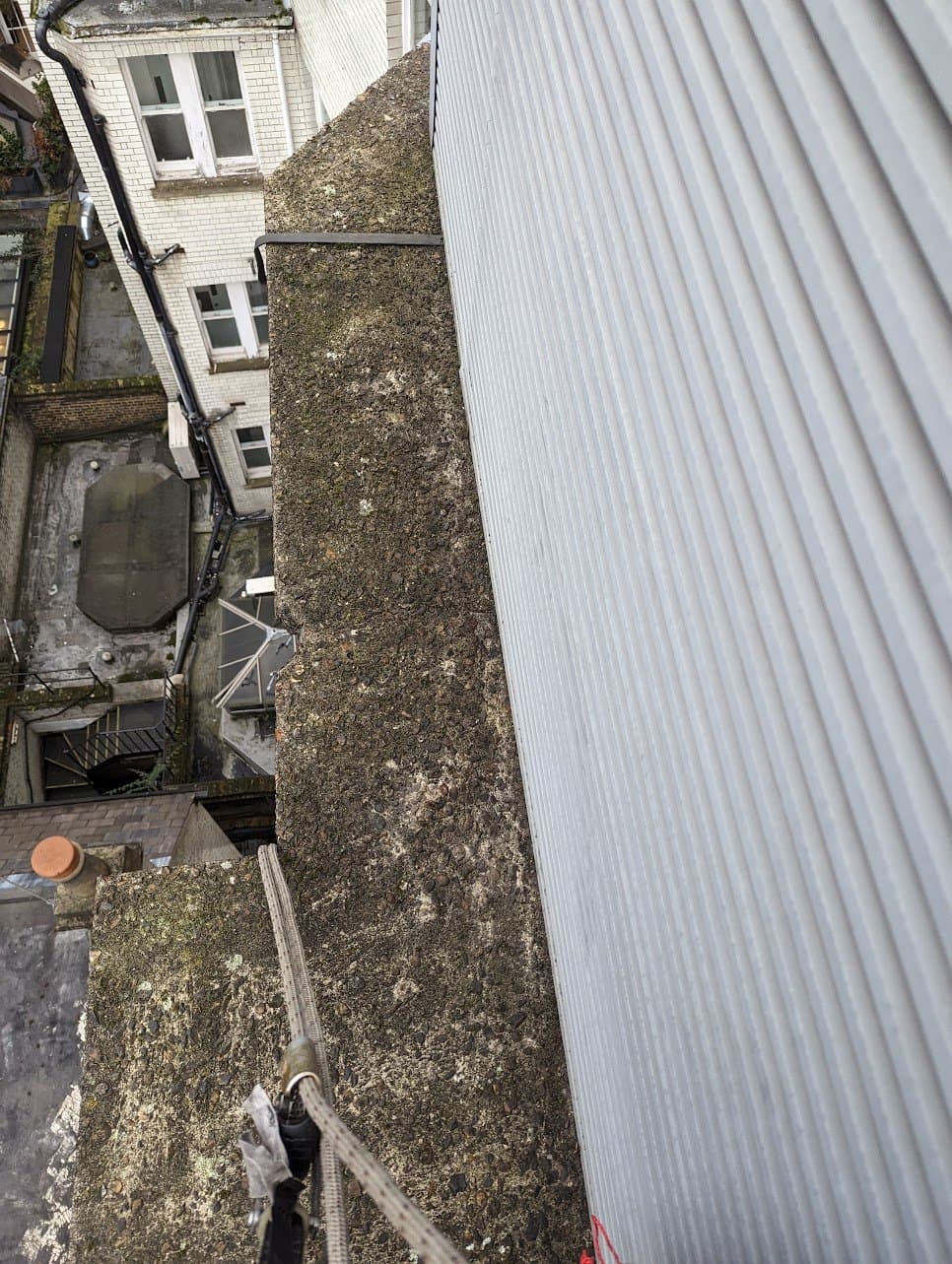 Looking down the rope line over a parapet coping to the courtyard below